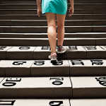 **Prompt 1:** A professional figure, initially slightly hesitant but gaining confidence, is shown ascending a staircase. Each step of the staircase is composed of abstract, positive words related to "feedback," "insight," and "growth." The background transitions from a slightly muted, uncertain tone to a vibrant, ascending pathway, symbolizing transformation and success achieved through well-received critique. The overall feel is empowering and optimistic, illustrating the concept of turning challenges into stepping stones.